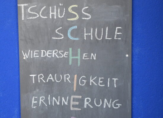 Tafel mit dem Wort Abschied als Buchstabenrätsel: Spaß, Neubeginn, Tschüss Schule, Wiedersehen, Traurigkeit, Erinnerung, Vorfreude