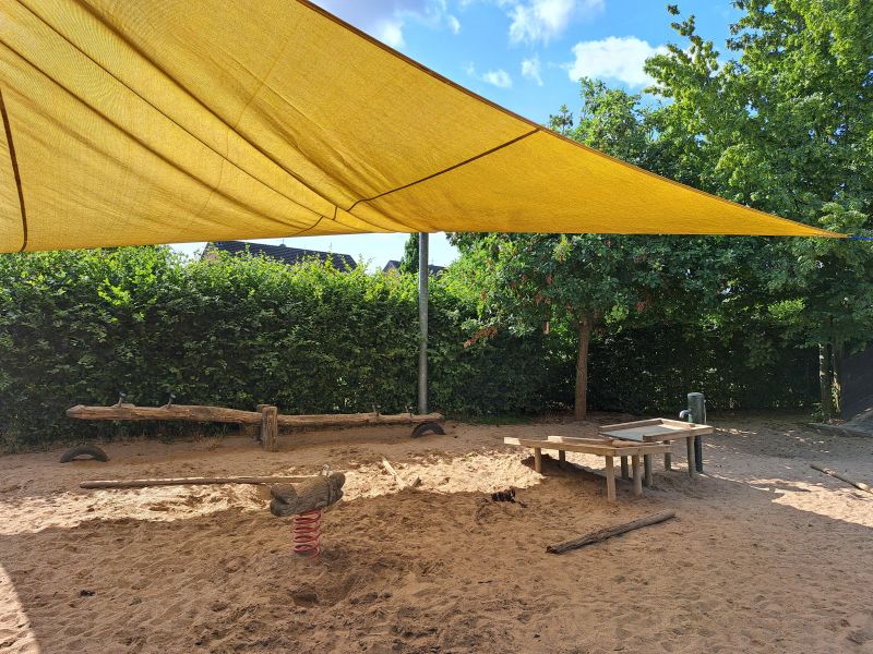Spielplatz der KiTa Am Krausacker mit Sandfläche und Sonnensegel